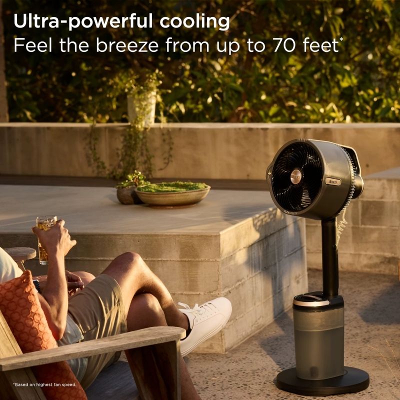 FlexBreeze Pro Mist Fan misting on a sunny backyard patio